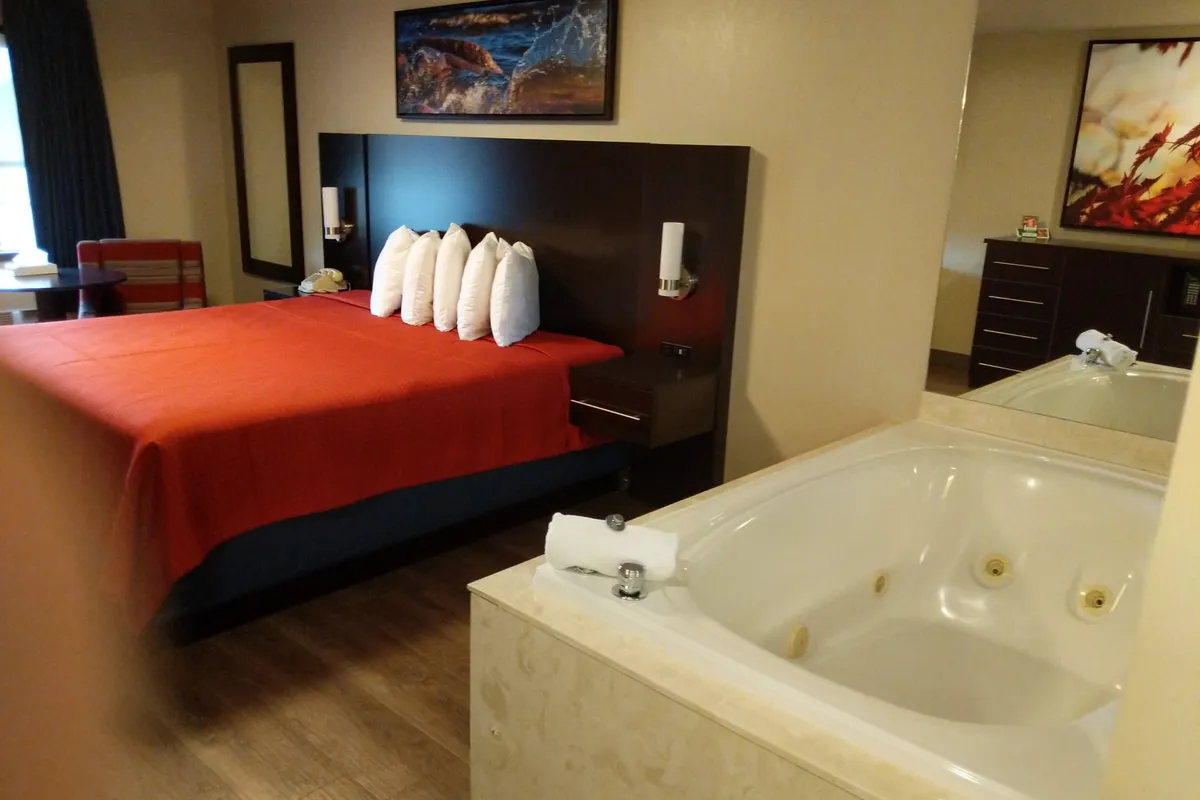 King bed beside a two-person jacuzzi tub in the King Jacuzzi Suite