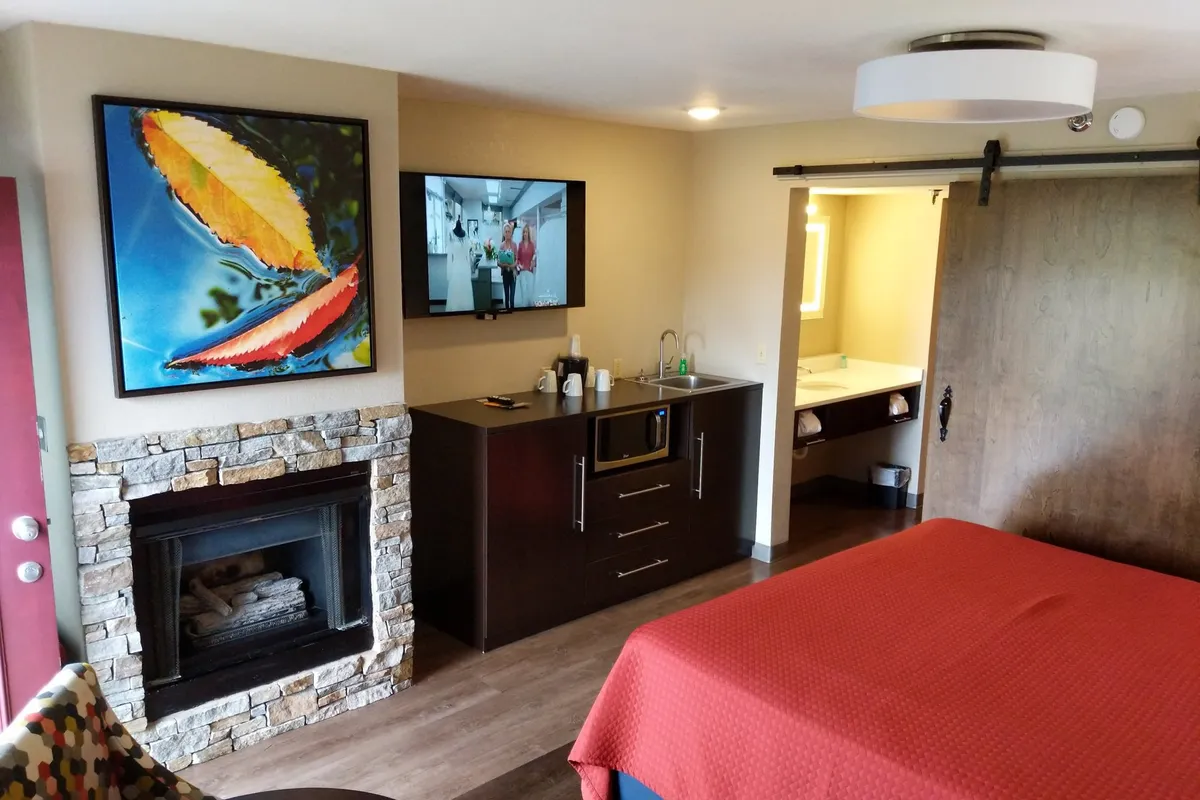 King suite with stone fireplace, flat-screen TV and red king bed