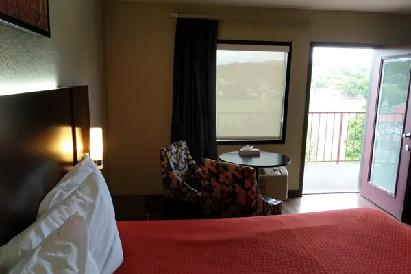 Bedroom with table, chairs and open balcony door